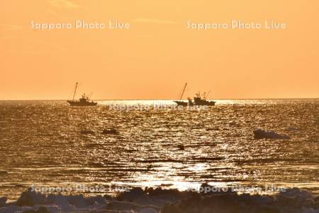 朝焼けとホタテ漁船と流氷