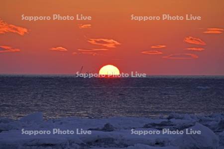 朝日とホタテ漁船と流氷