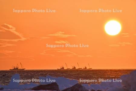 朝日とホタテ漁船と流氷