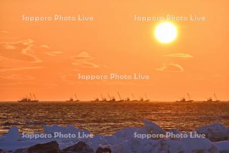 朝日とホタテ漁船と流氷