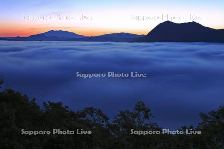 夜明の霧に覆われた摩周湖と摩周岳