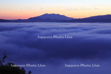 夜明の霧に覆われた摩周湖と斜里岳
