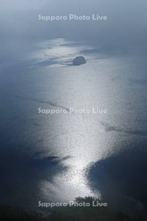光る摩周湖の湖面とカムイシュ島