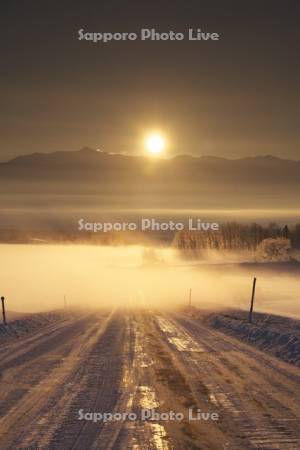 十勝岳連峰の日の出と朝霧と道