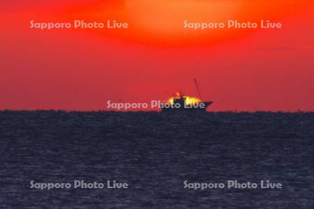 根室海峡の日の出とホタテ漁船