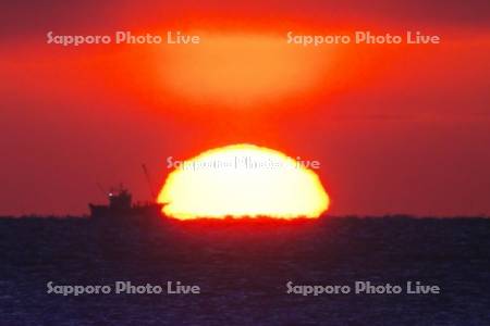 根室海峡の日の出とホタテ漁船