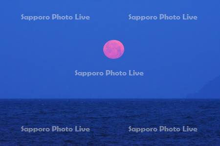 日本海に沈む赤い月と松前小島（右）