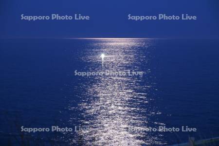 朝の月明かりの海と漁船