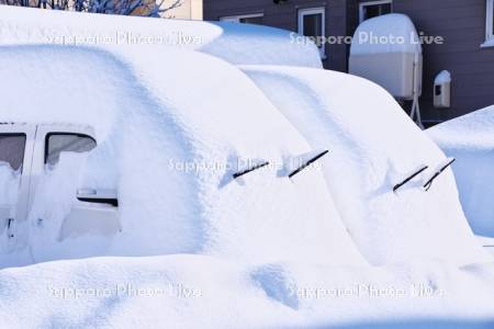 大雪で埋もれた車（ワイパーを立てている)