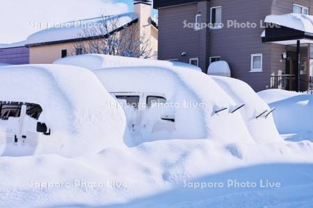 大雪で埋もれた車（ワイパーを立てている)