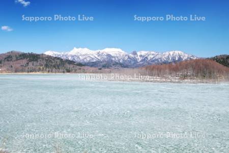 氷の残るシューパロ湖と夕張山地