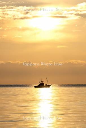 朝陽とホッキ漁船