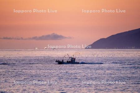 朝焼けと漁船