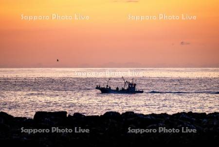 朝焼けと漁船