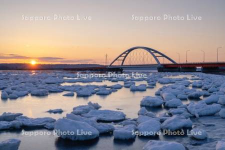 日の出と温根沼大橋と流氷