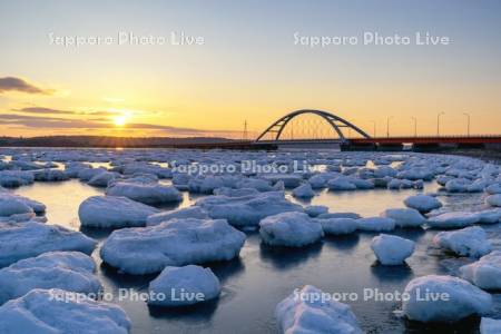 日の出と温根沼大橋と流氷