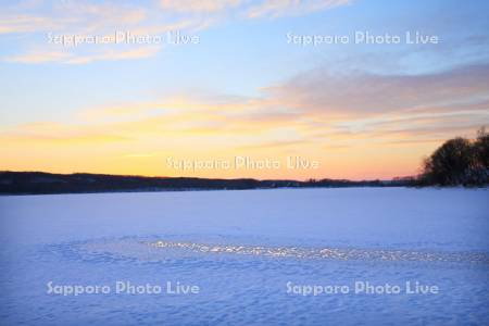 塘路湖の湖面と夕日