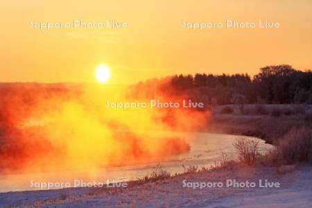 日の出に燃える釧路川