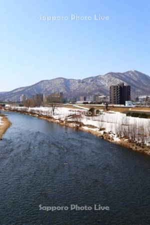 雪解けの豊平川と藻岩山