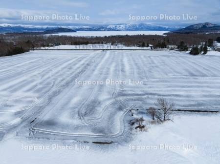 融雪用木炭散布の畑と屈斜路湖
